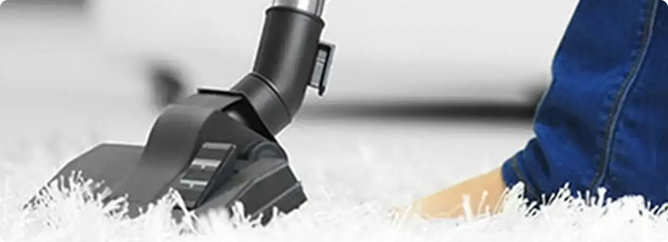 Close-up of a professional vacuuming a white carpet in Gardena.