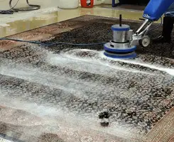 Professional rug cleaning with a rotary floor machine and shampoo foam, deep-cleaning an area rug, in Los Angeles, CA.